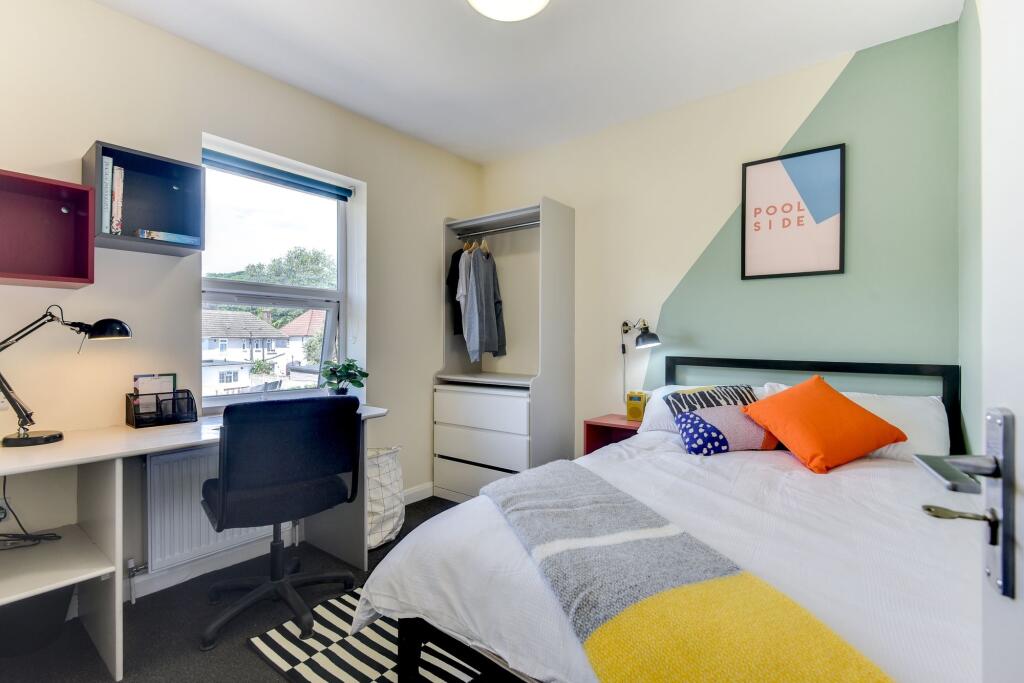 This cozy double bedroom features a comfortable...