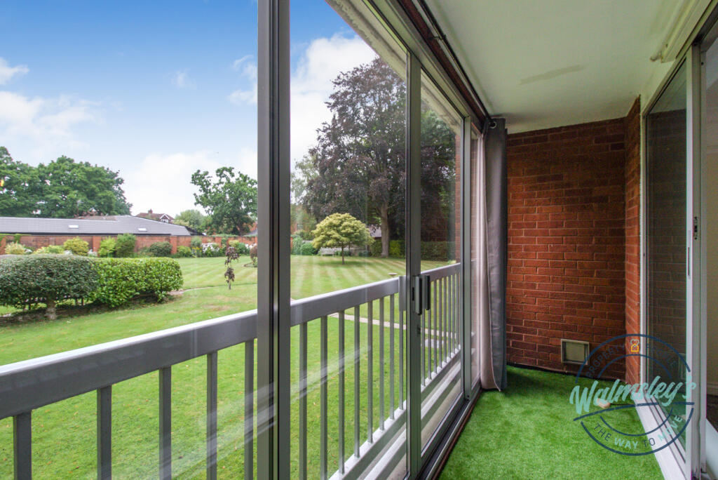 Enclosed balcony with sliding doors overlooking ga