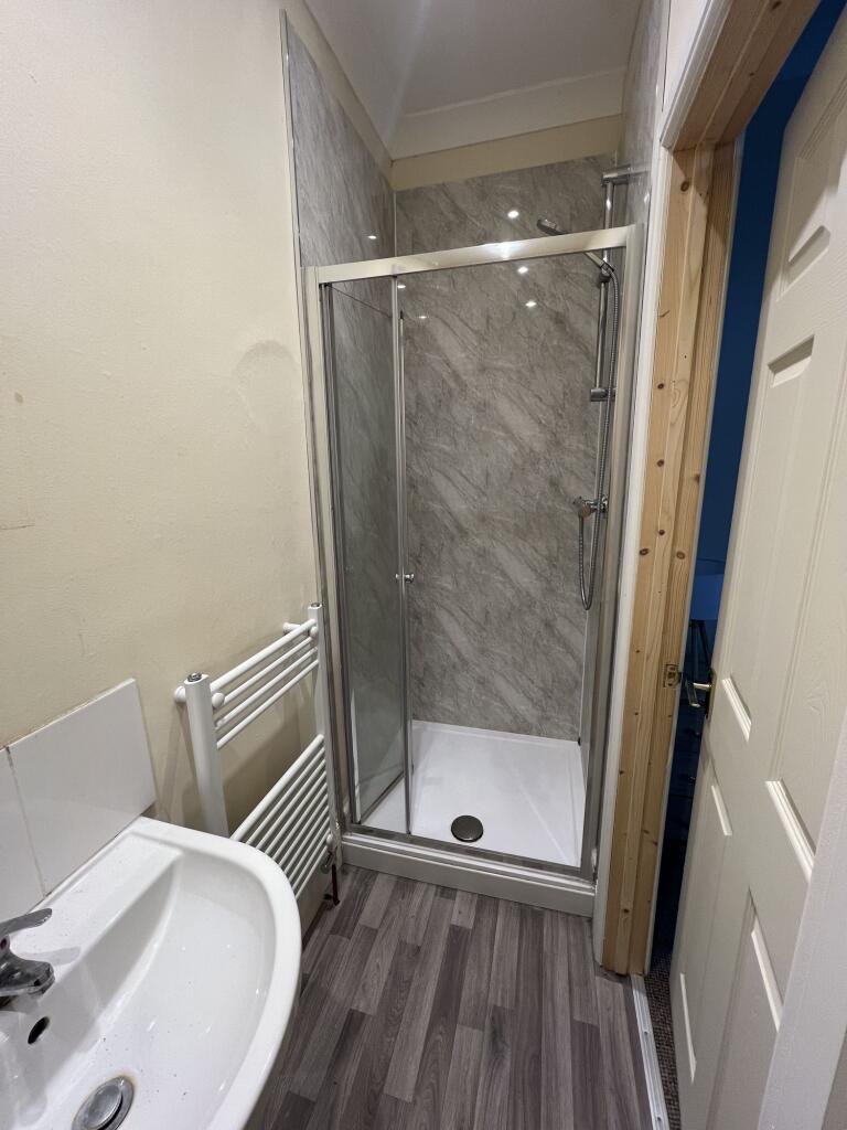A neat and modern bathroom featuring a glass-en...