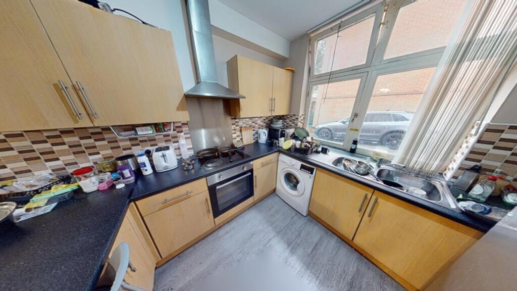 A well-lit kitchenette with ample storage and m...