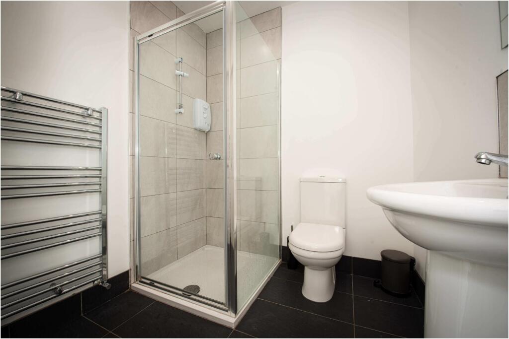A modern, clean bathroom with a spacious shower...
