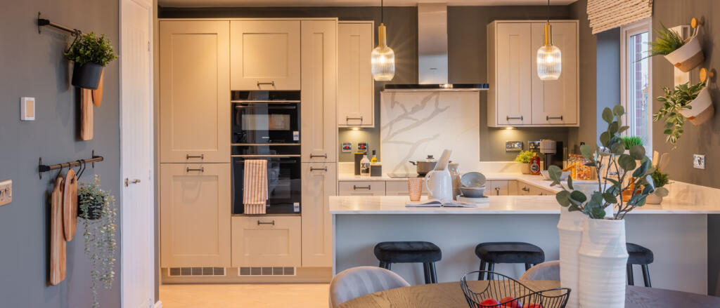 Modern kitchen with creamy-white shaker-style cabinets, integrated double oven, a white island/break