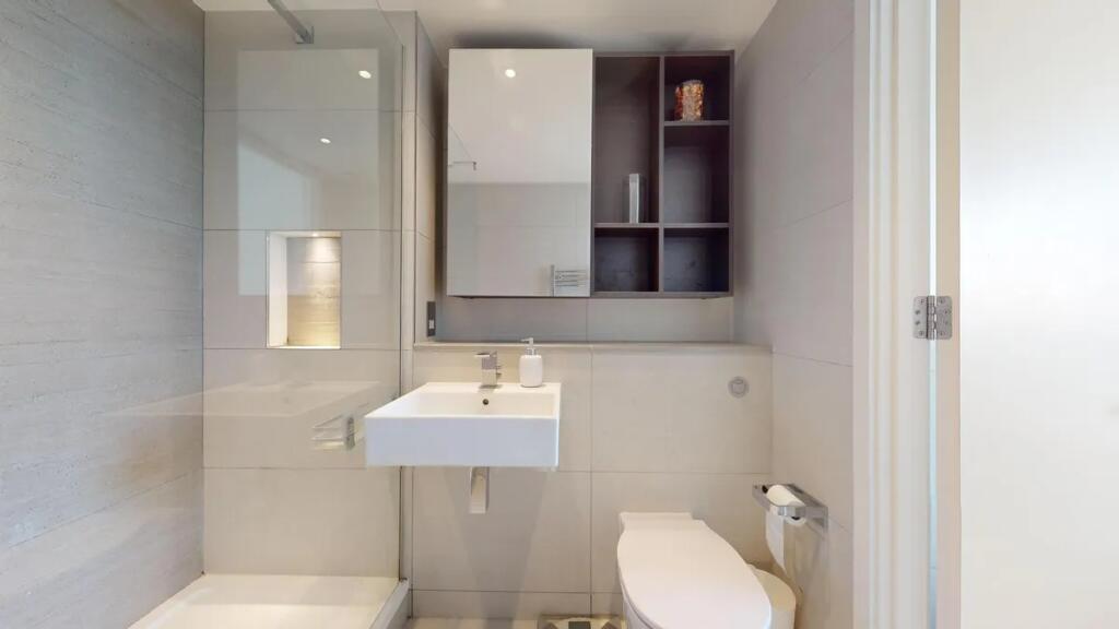 A modern, immaculately clean bathroom featuring...