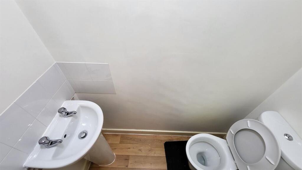 A clean and simple single toilet with a white s...