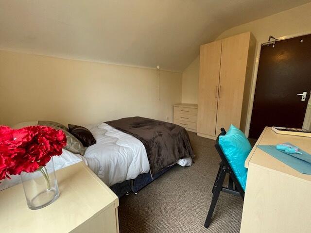 Cozy single bedroom featuring a neatly made bed...