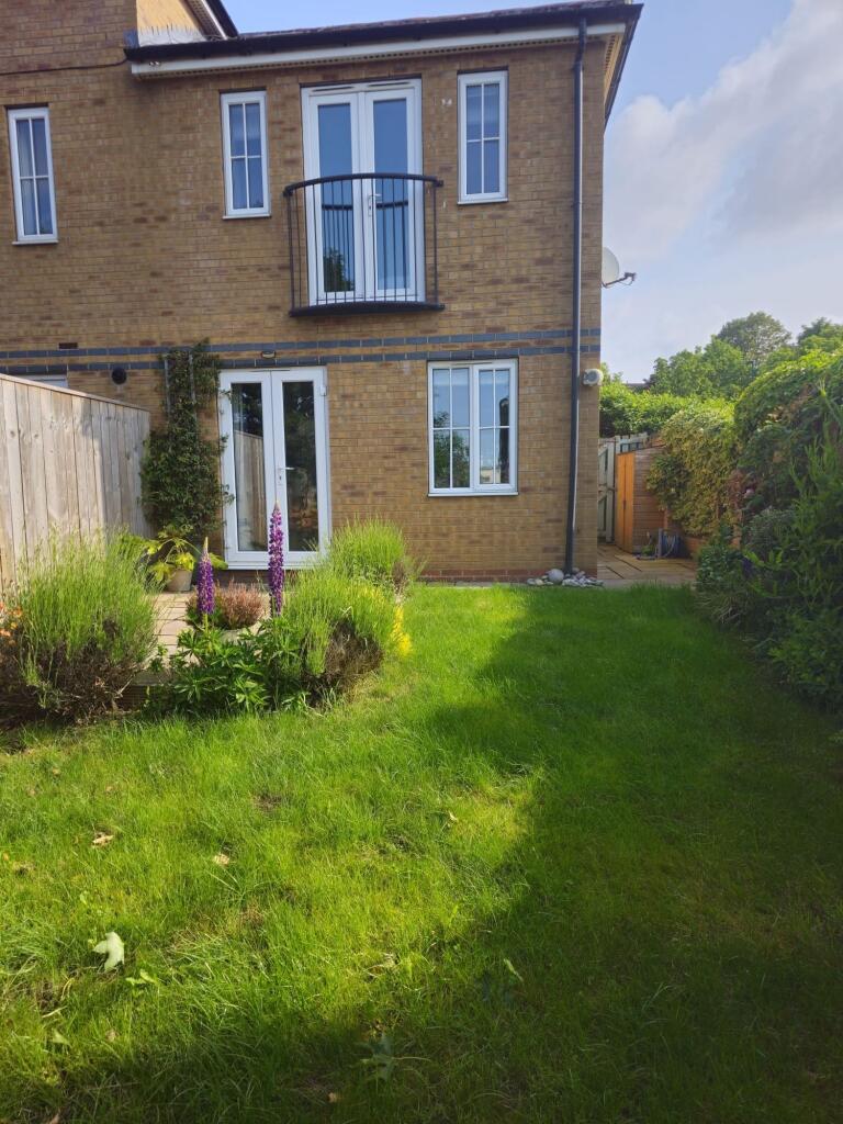 A well-maintained garden with lush green grass,...