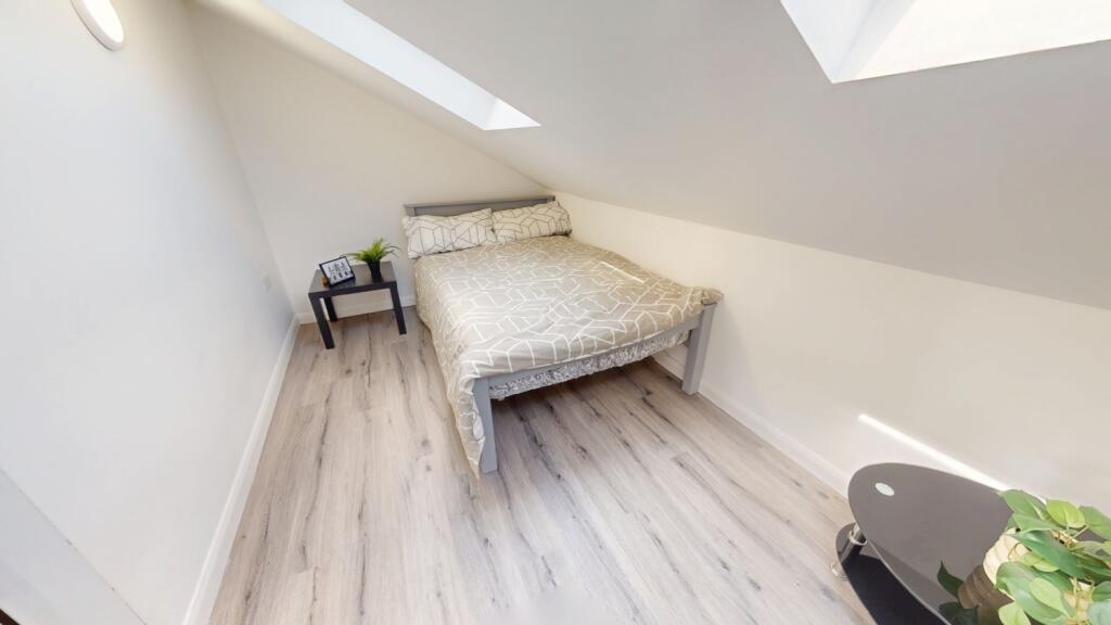 A clean and bright single bedroom featuring a c...