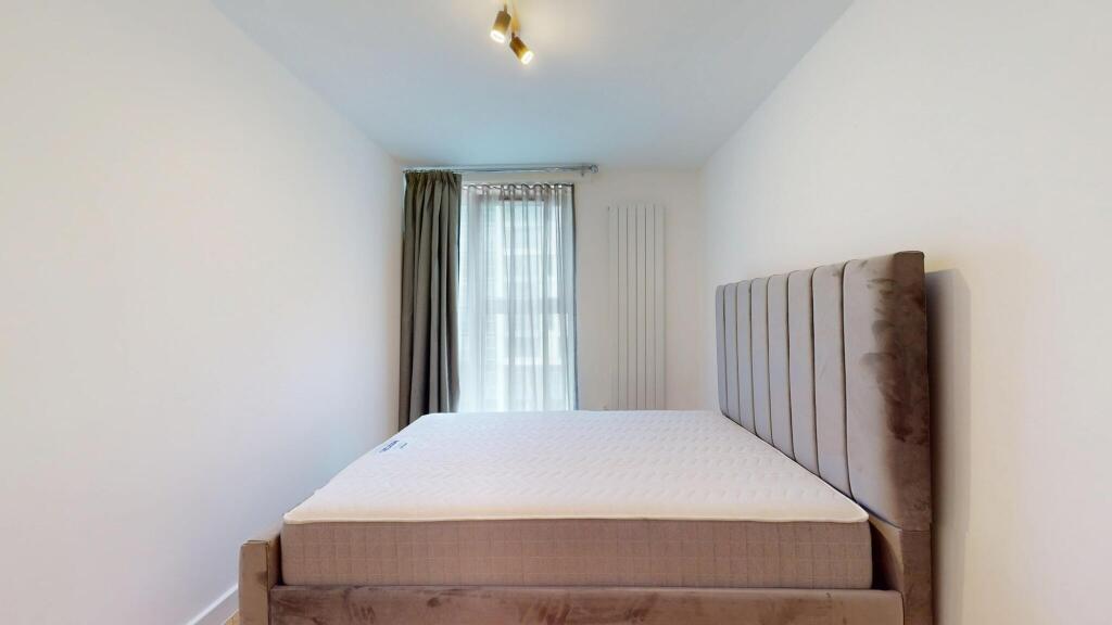 A modern double bedroom featuring a plush uphol...