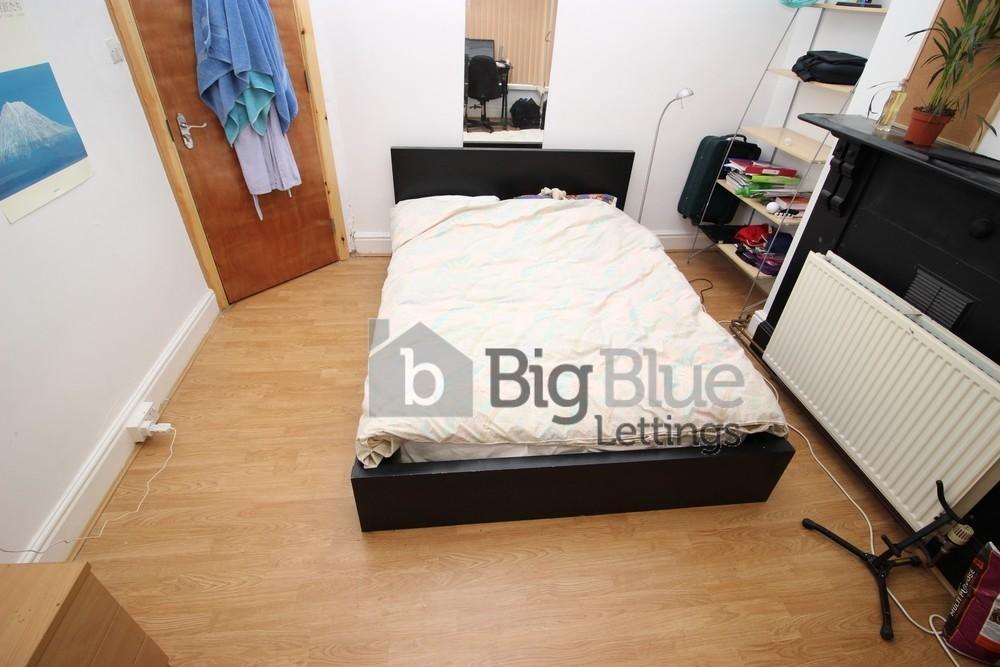 A tidy, compact bedroom featuring a simple bed ...