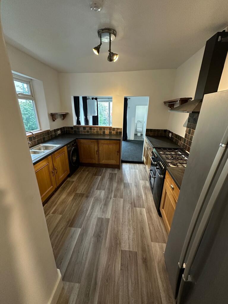 Modern kitchen with wood-effect flooring, ample...
