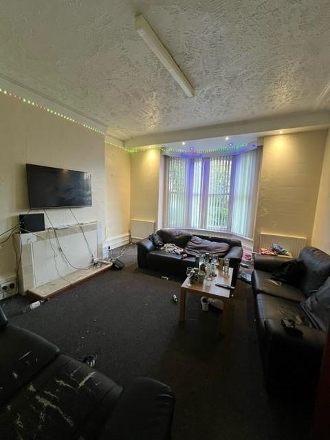 A spacious, well-lit living room featuring mode...