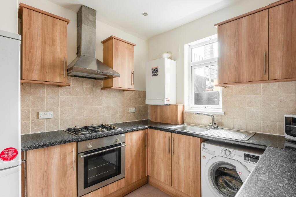 Bright and modern kitchen featuring wooden cabi...