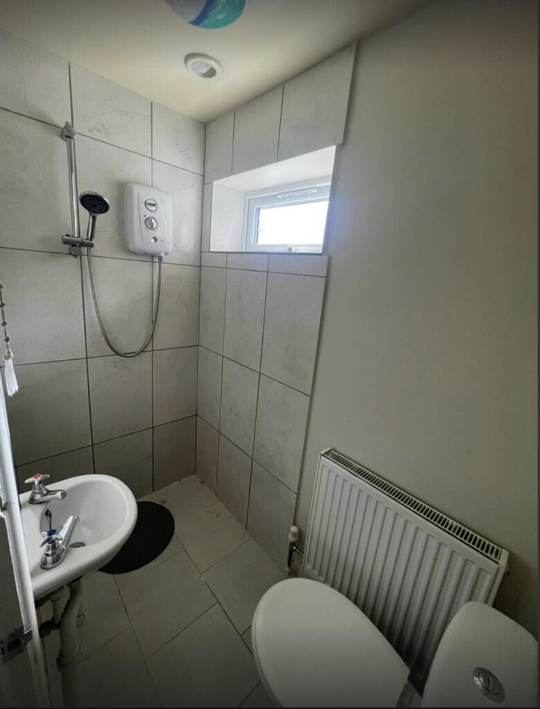 A clean bathroom with a shower and basic fixtur...