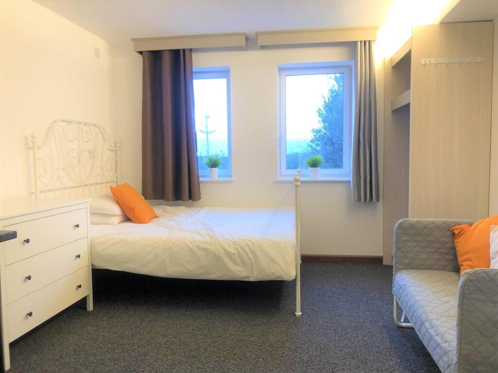 A tidy and bright single bedroom featuring two ...