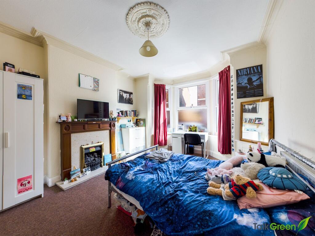 A cozy bedroom featuring a bed with stuffed toy...