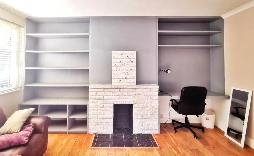 Bright living room with built-in shelving surro...