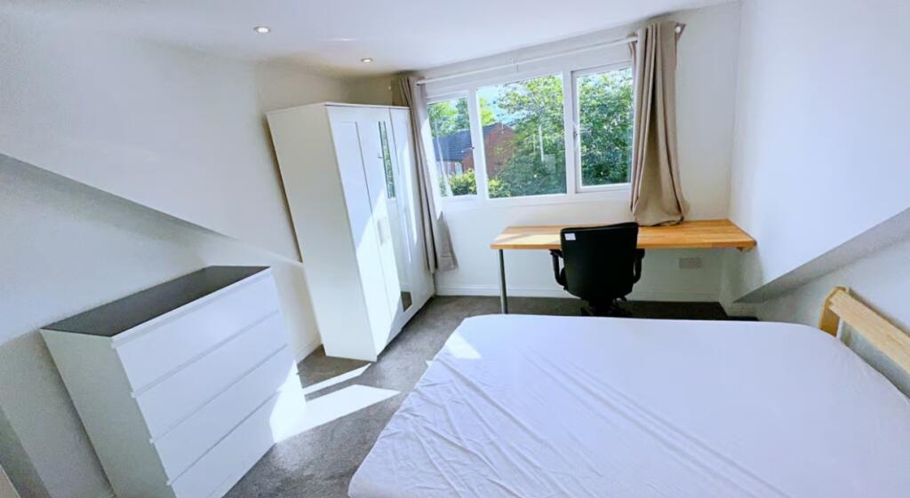 This inviting double bedroom features a large w...