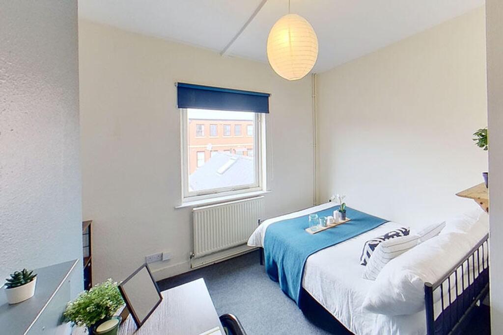 This inviting double bedroom features a cozy at...
