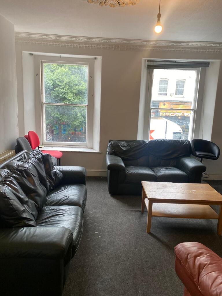 A cozy living room with two black leather sofas...