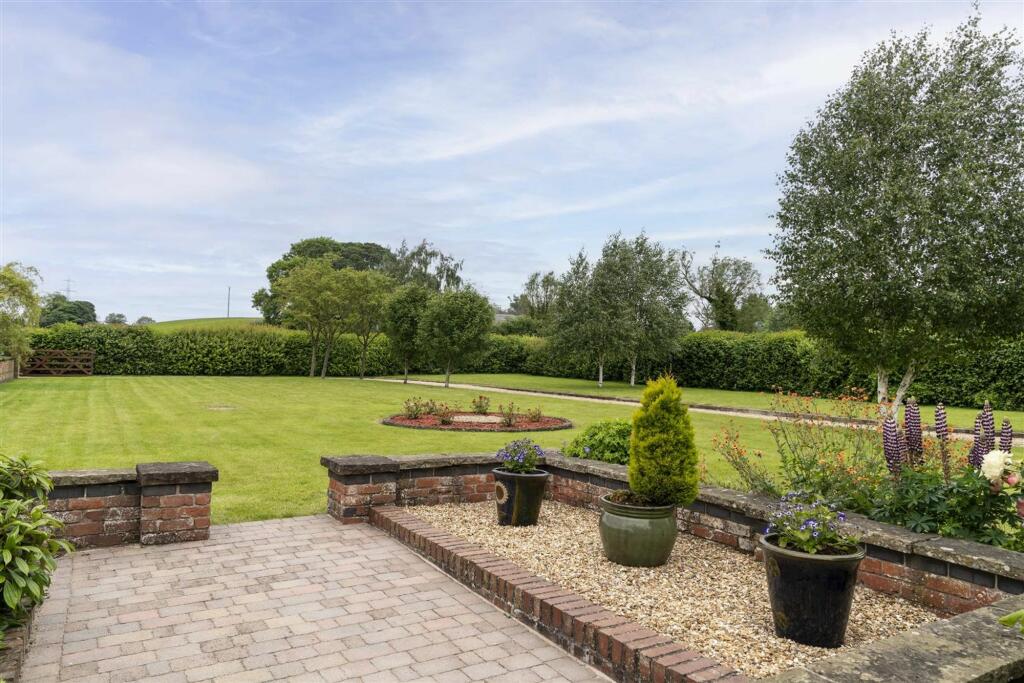 Beautifully manicured garden with large drive