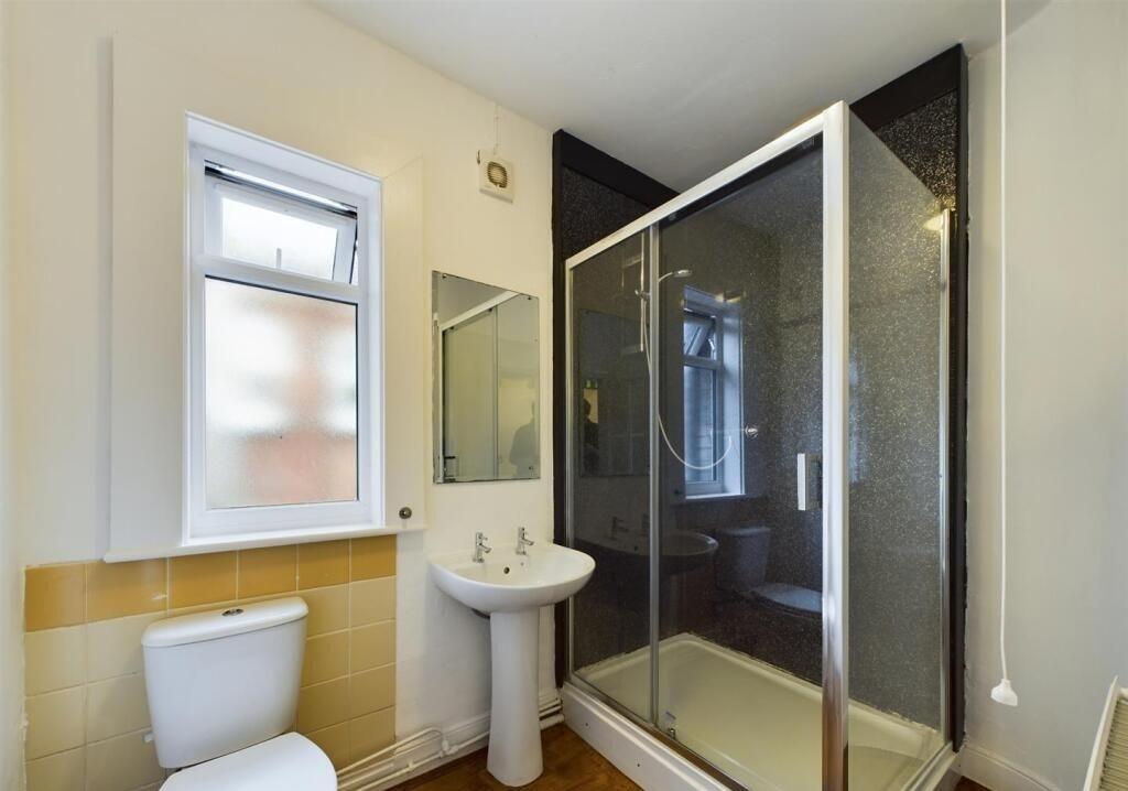 Bright and tidy bathroom featuring a spacious s...