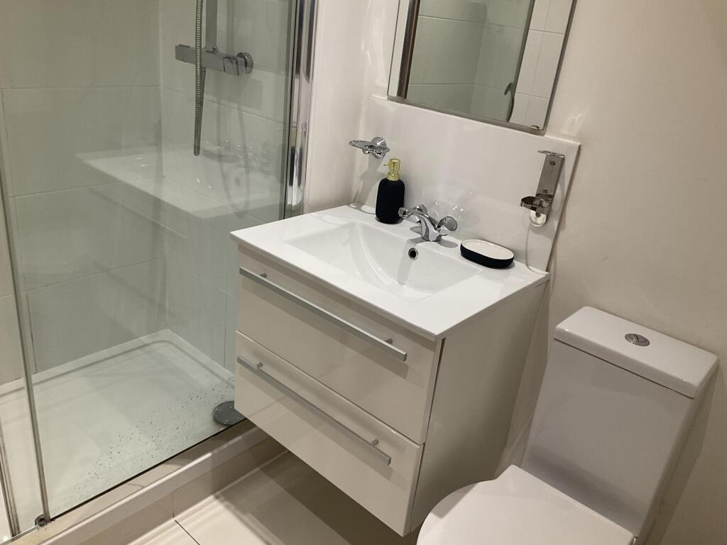 Modern bathroom suite featuring a sleek glass-e...