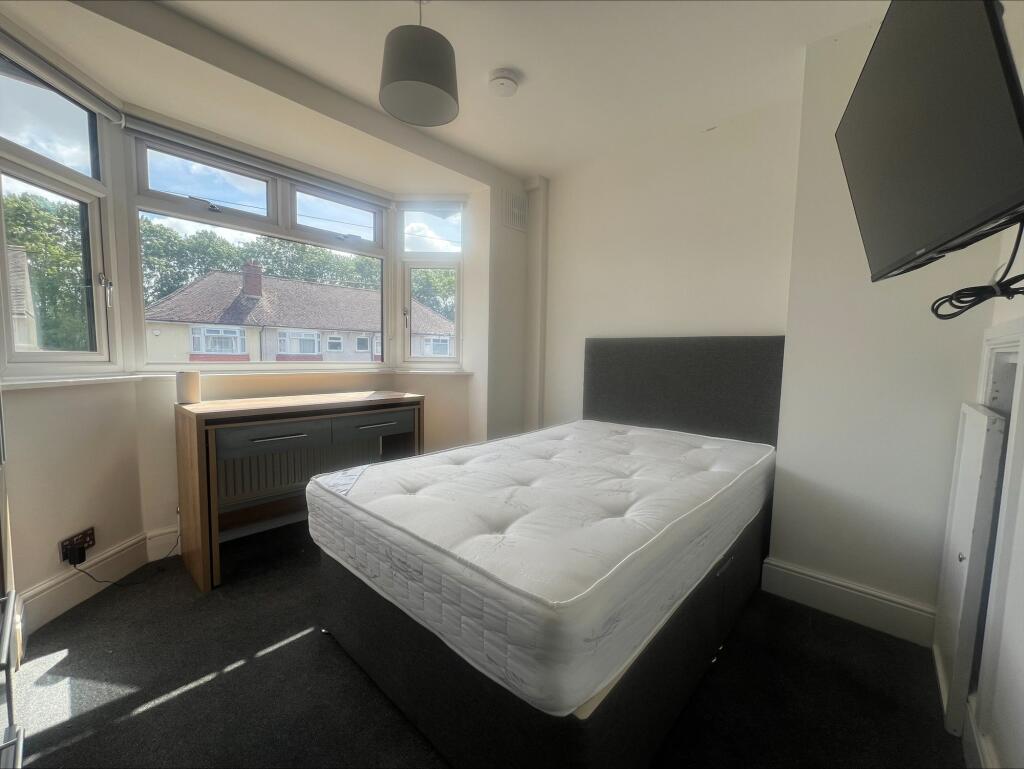 Bright double bedroom featuring a comfortable b...