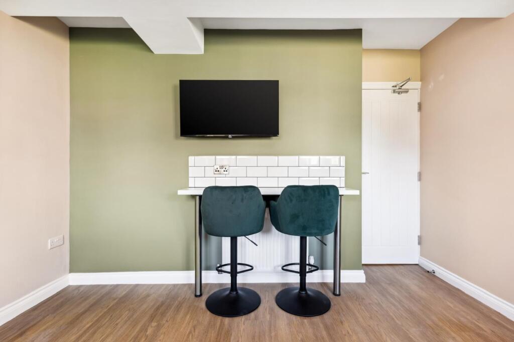 A modern communal workspace featuring a sleek b...