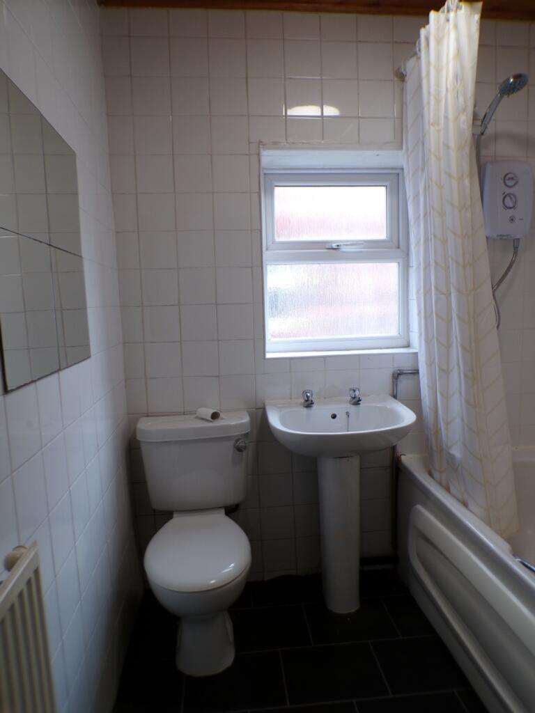 A well-maintained bathroom featuring a bath, si...