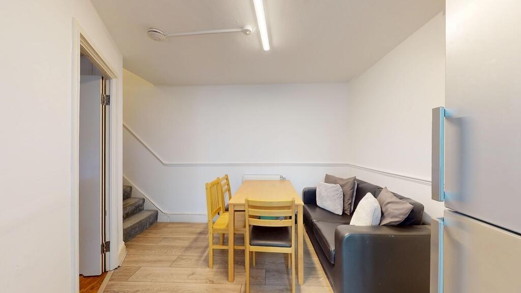 A cozy living room featuring a small black sofa...