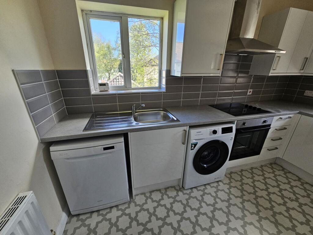 Bright and modern kitchen featuring a large win...