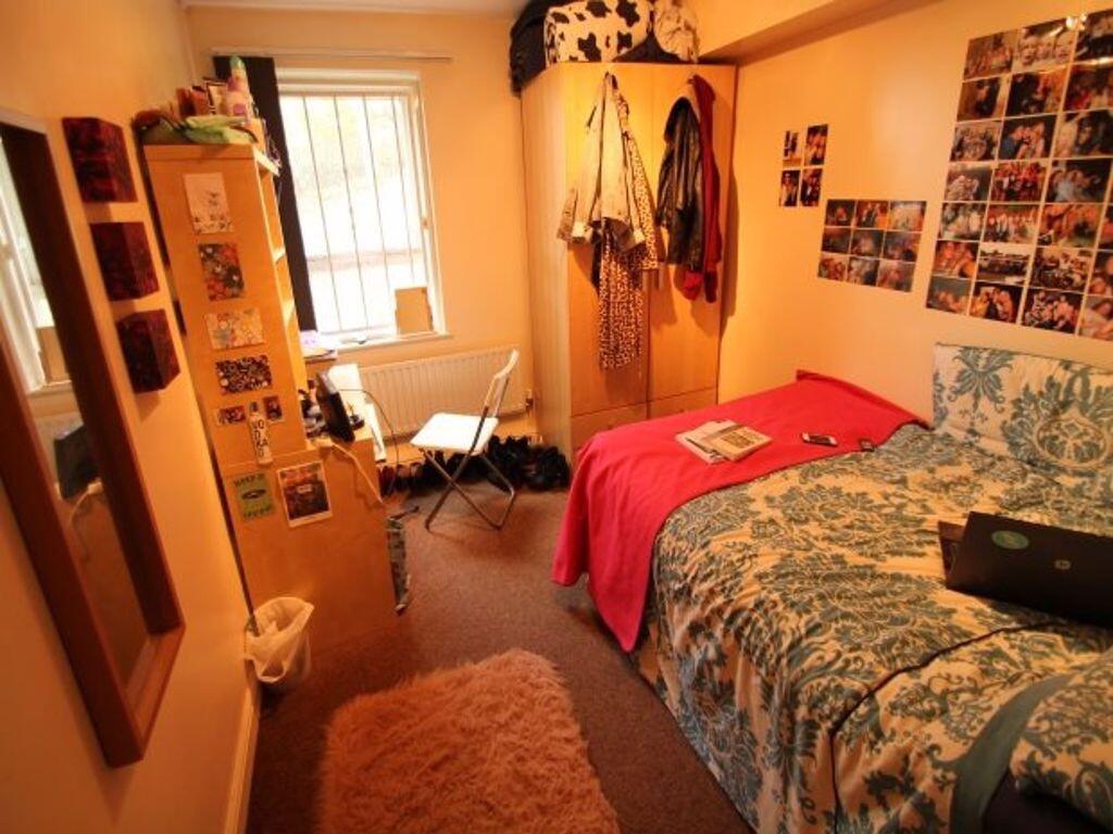 Cosy single bedroom with a neatly made bed, wal...