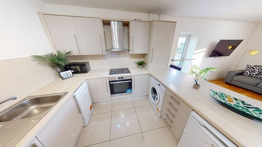 A modern, clean kitchen featuring light counter...