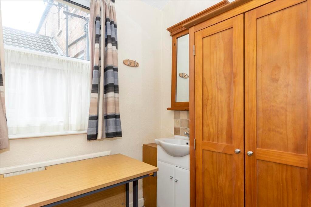 This cozy double bedroom features a warm wooden...