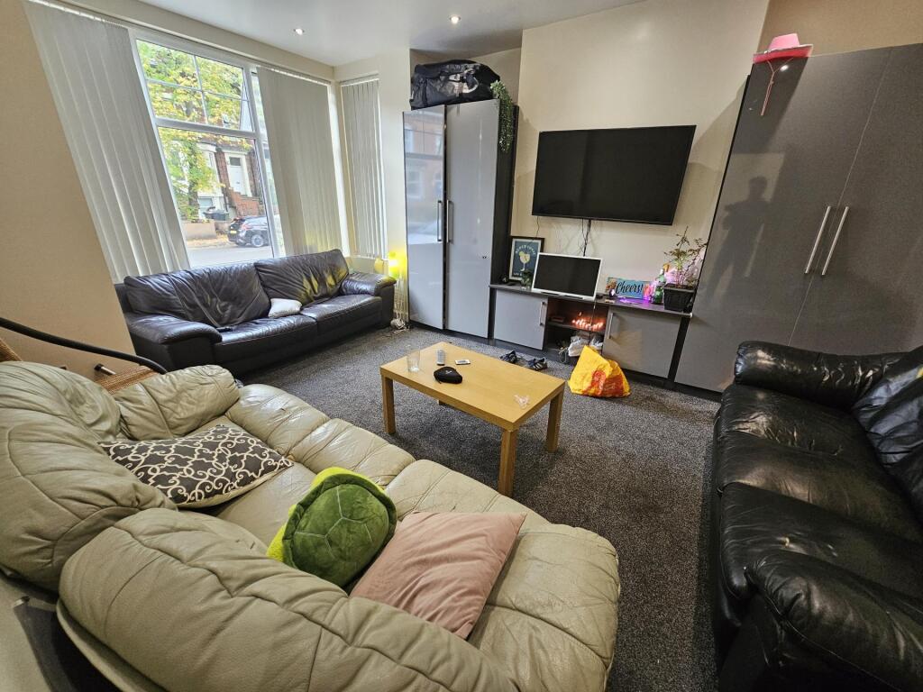 A cozy, well-lit living room featuring comforta...