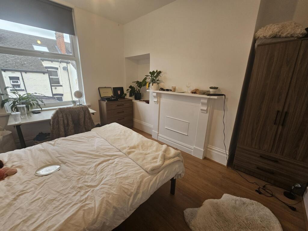 A cozy bedroom with a large window allowing nat...