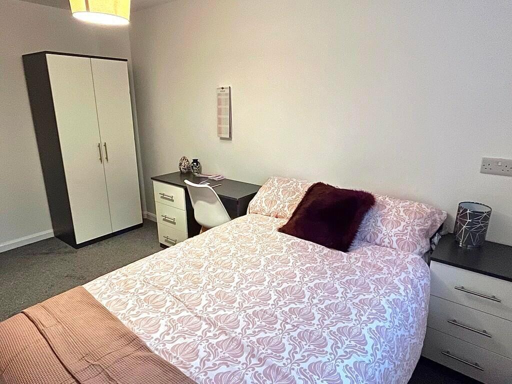 A clean and cozy double bedroom featuring a com...