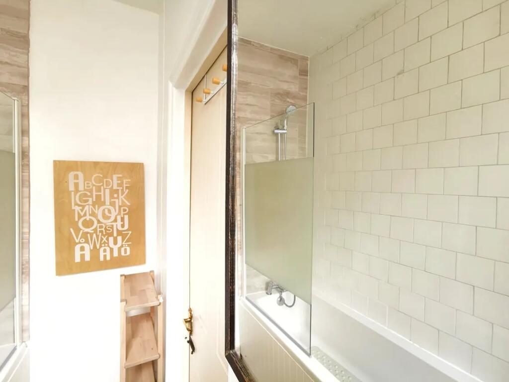 Bright and clean bathroom suite featuring a mod...
