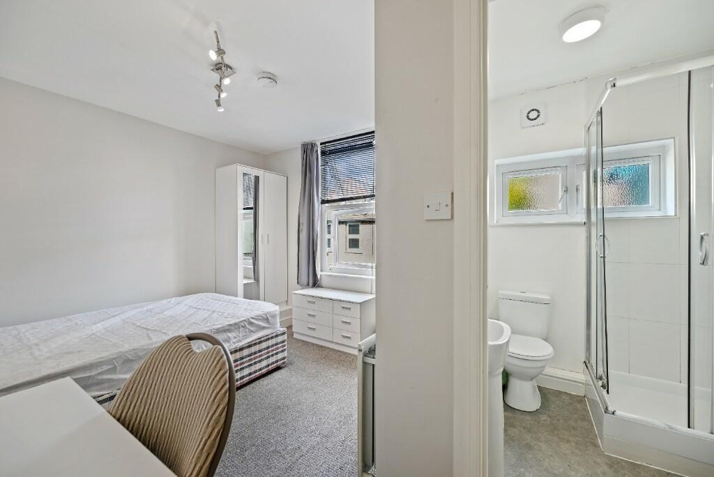 Bright and neatly arranged bedroom featuring a ...