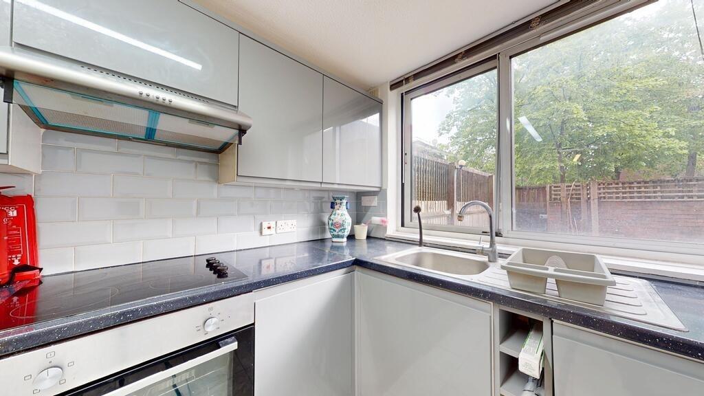 Bright and modern kitchen featuring white cabin...