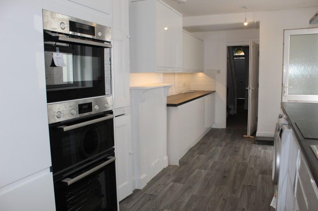 A sleek and modern kitchen featuring clean whit...