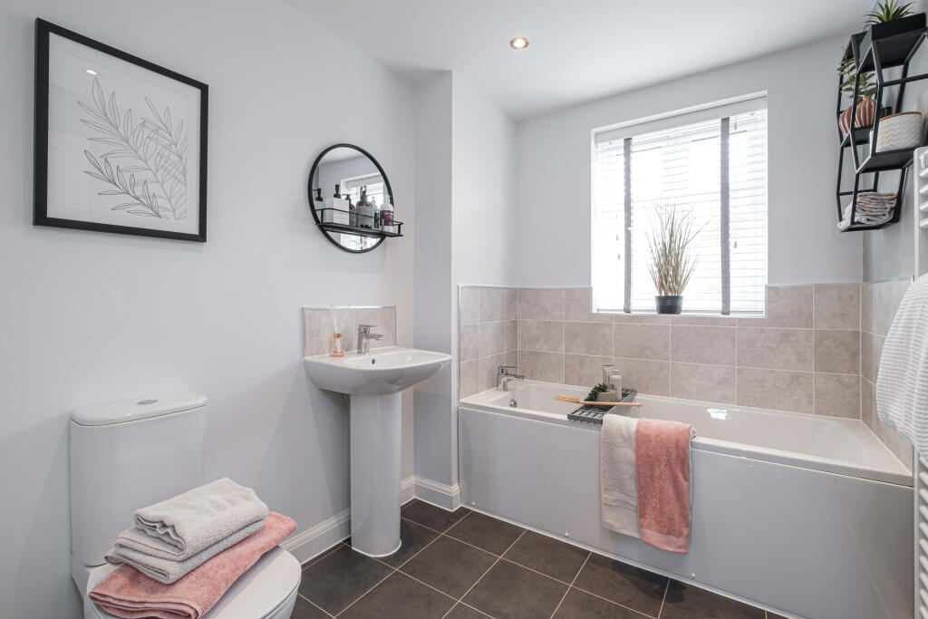 photo of a modern grey tiled bathroom with bath