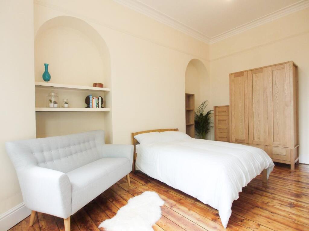 Bright and airy master bedroom featuring a comf...