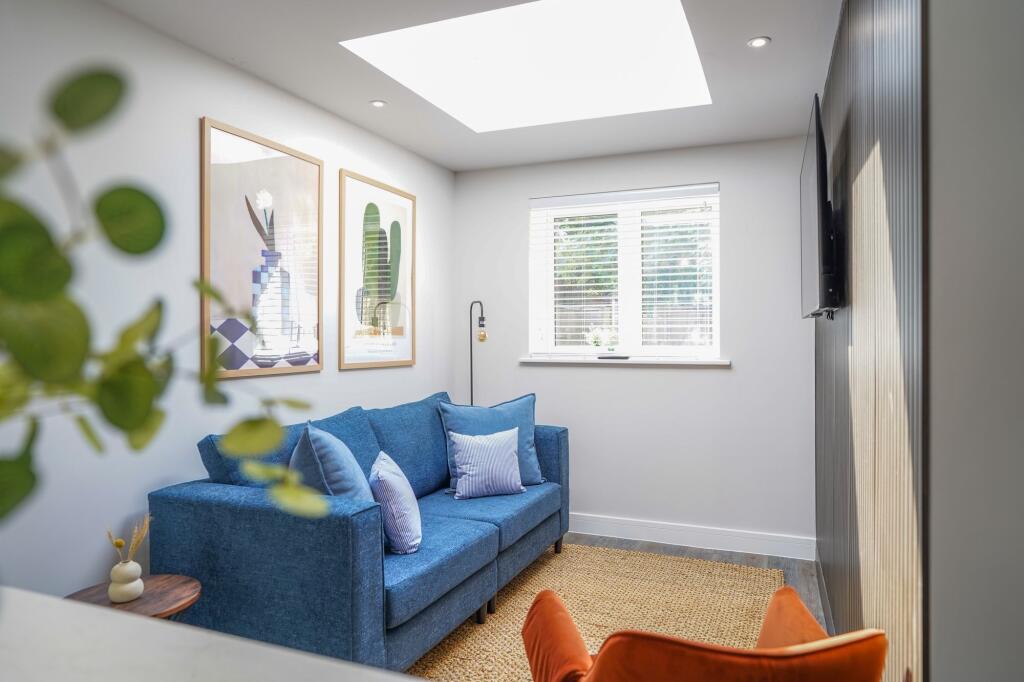 Bright and modern living room featuring a comfo...