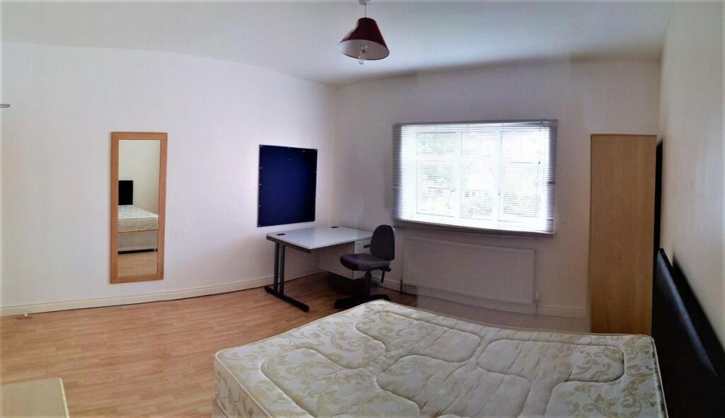 A bright and tidy double bedroom featuring a la...