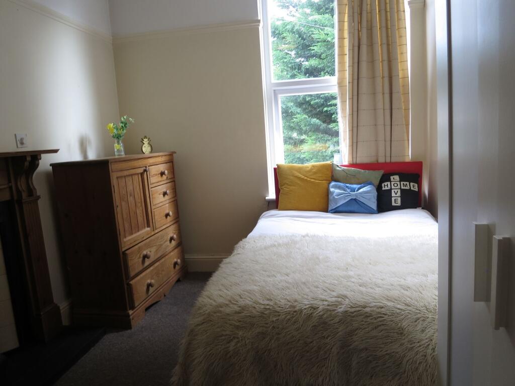 A cozy, well-lit bedroom featuring a large wind...