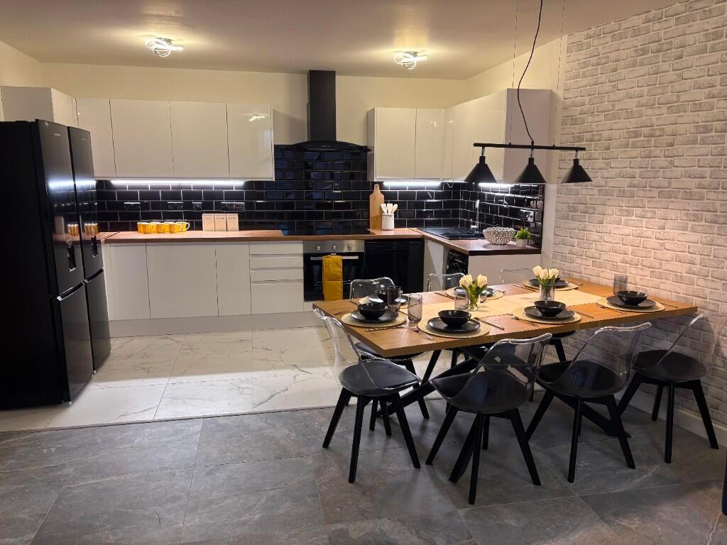 A modern kitchen with sleek white cabinetry and...