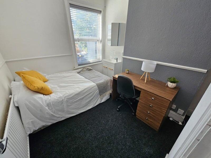 A cozy bedroom featuring a single bed with brig...