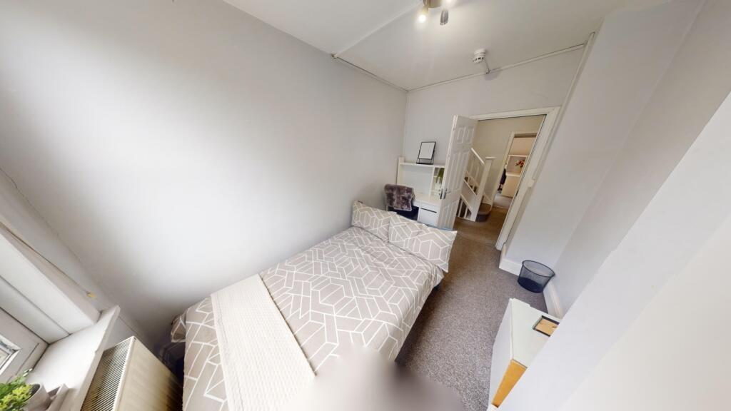 A bright and tidy single bedroom featuring a ne...