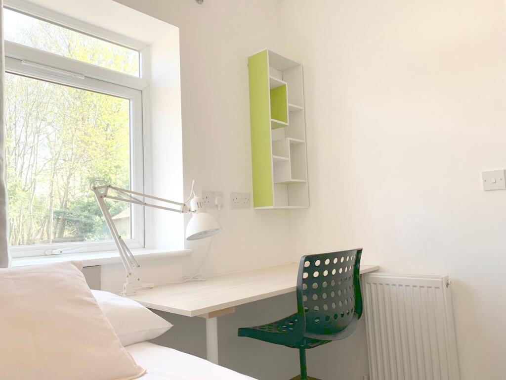 Bright and tidy single bedroom featuring a cozy...